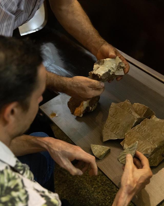 pedaços da lápide original e pedras que ainda restam no local